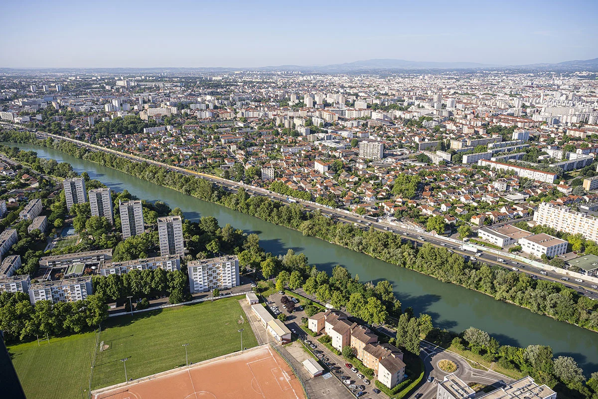 Photographie aérienne du quartier Saint-Jean à Villeurbanne avec ses immeubles et le canal de Jonage qui le borde.