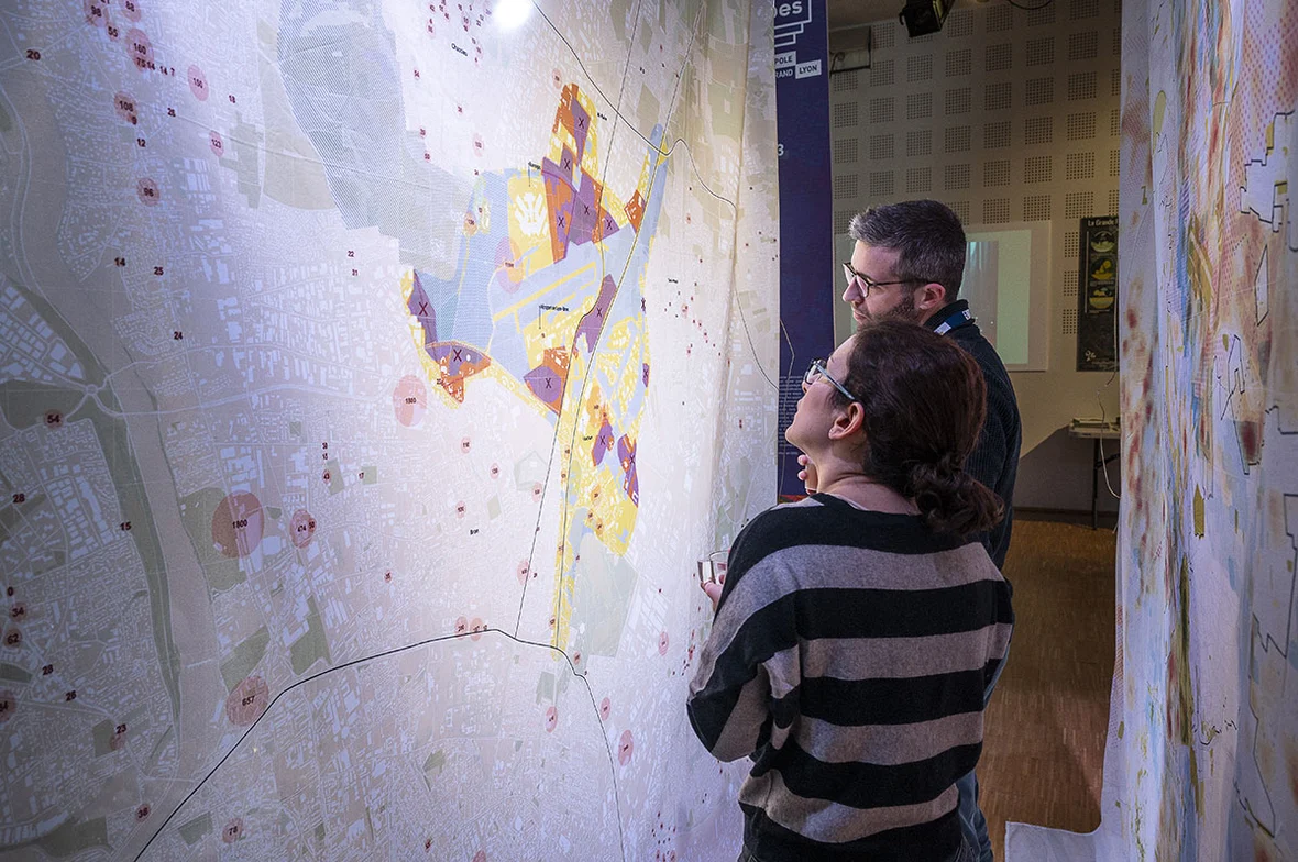 Une photo avec deux personnes regardant une carte lors du séminaire Grande Porte des Alpes, immersions 2050