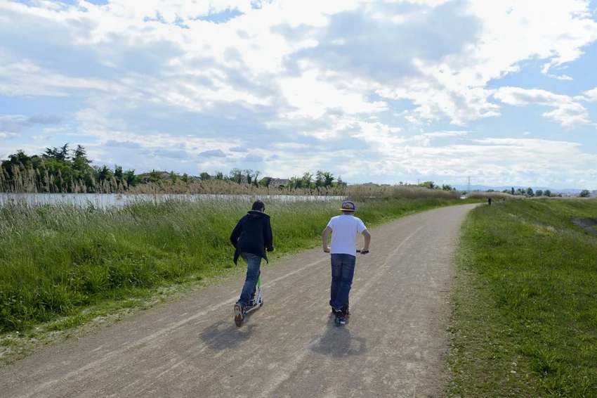 Deux personnes faisant de la trottinette long du canal de Jonage