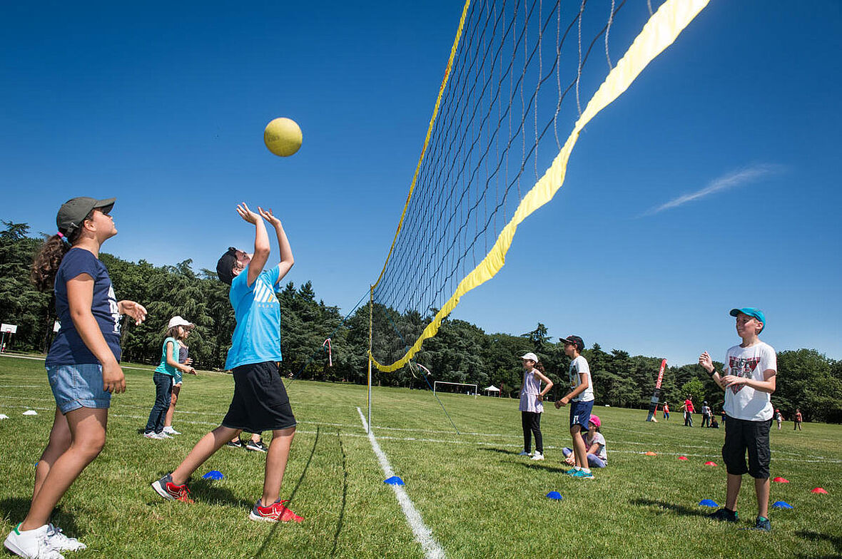 Des jeunes qui jouent au volley sur l'herbe