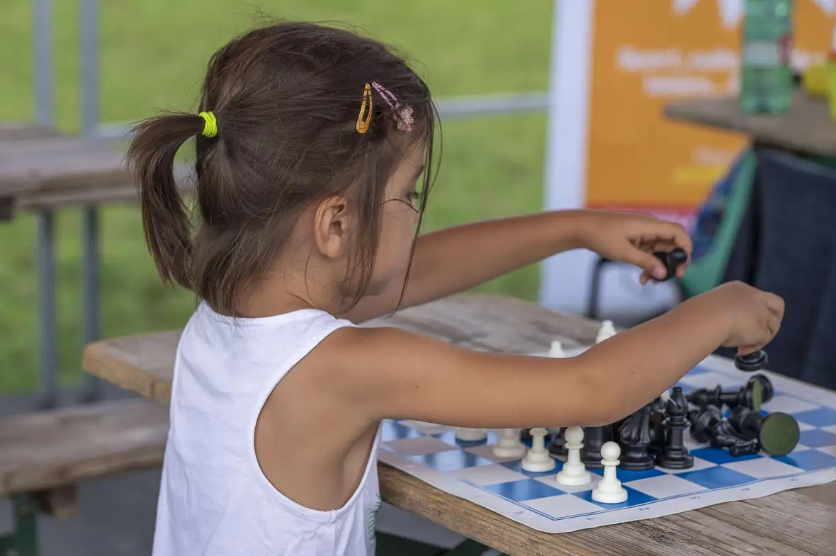 une enfant place les pions d'échec sur l'échiquier