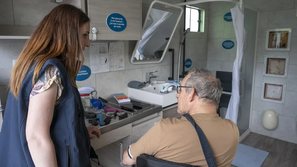 Photo de l'intérieur du camion aménagé de Soliha qui montre un espace cuisine et un espace salle de bain. 