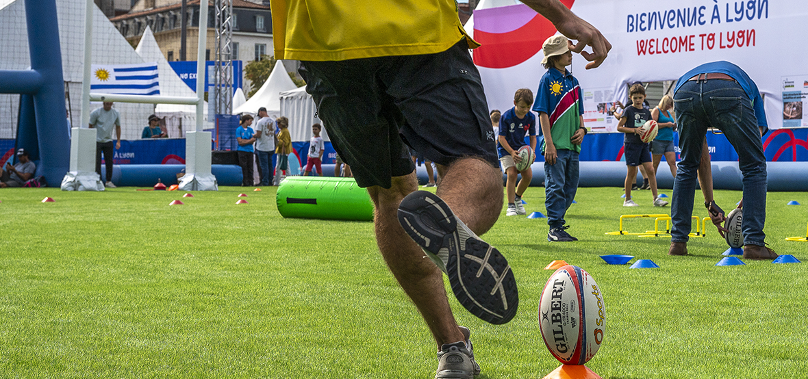 photo du village rugby, avec une personne tirant dans un ballon de rugby